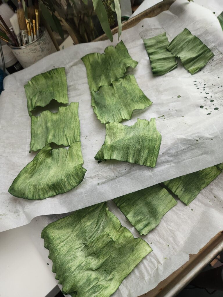 Green strips of paper drying on a metal tray. 